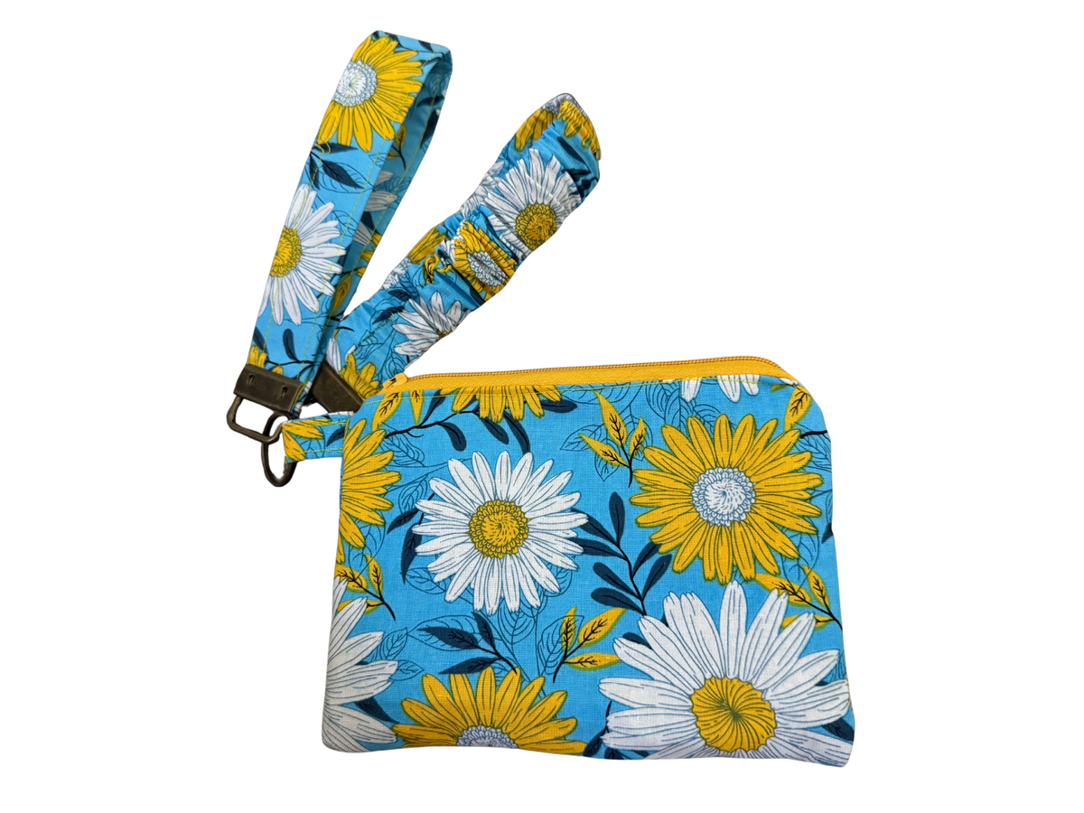Zipper pouch wristlet keychain in Blue Daisy, white and yellow daisies on sky blue, with a key fob strap and a scrunchie strap