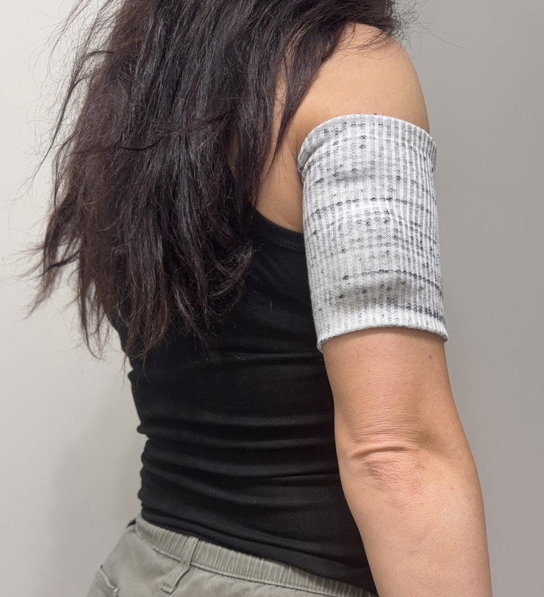 Black and white marled ribbed pod band worn on the upper arm over a pod