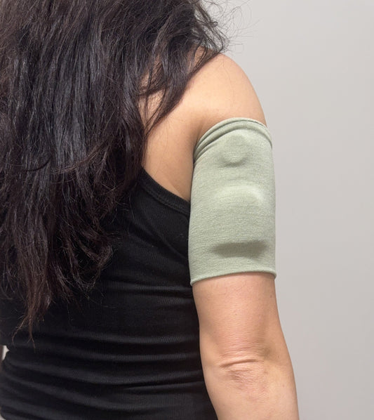 Soft cotton-feel pod band in Sage Green worn on the upper arm over a pod