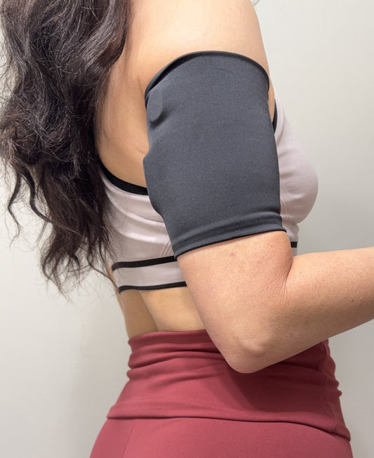 Grey Sport pod band worn on the upper arm over a pod with a sports bra
