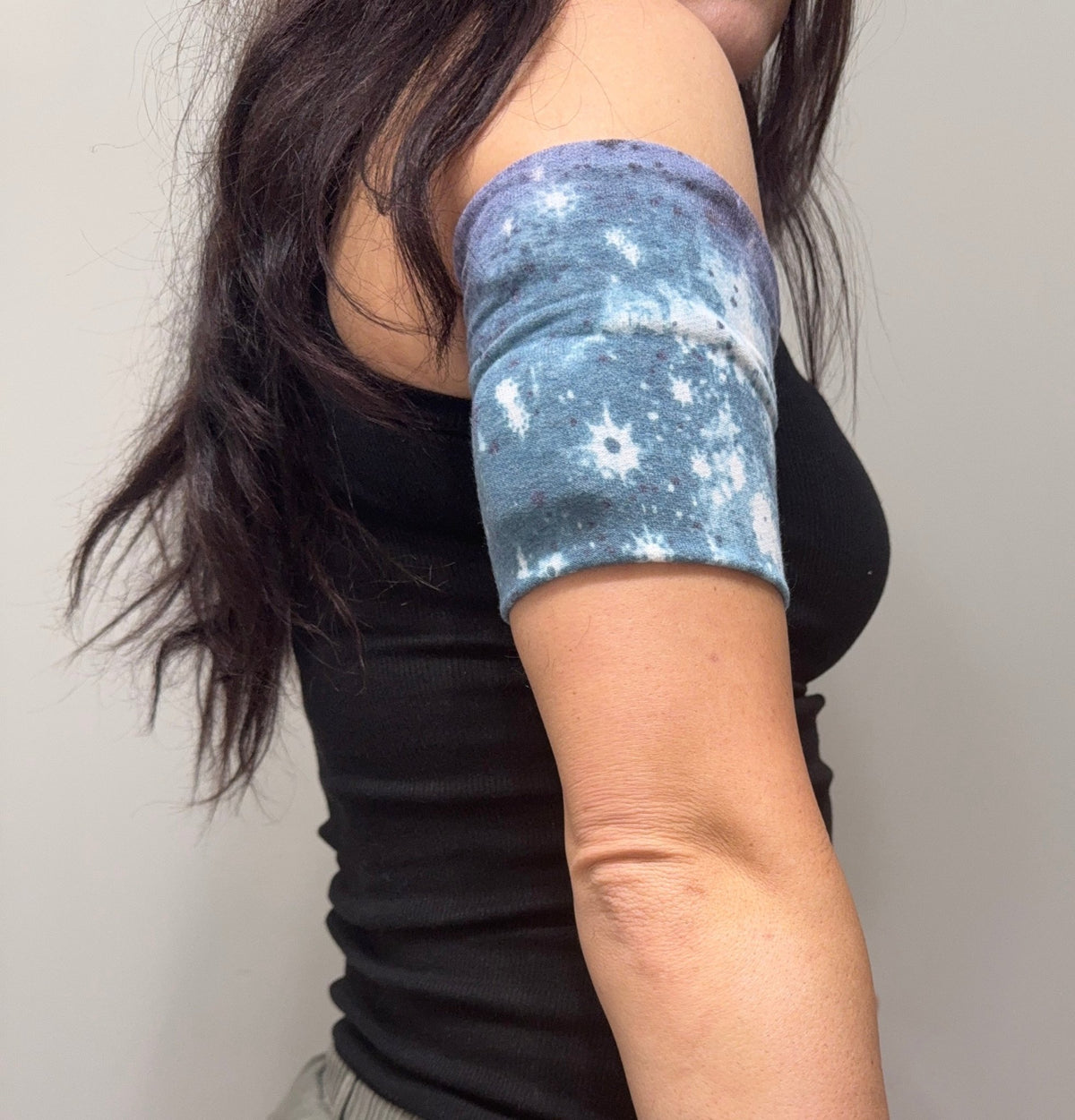 Cozy pod band in Purple, White & Blue Tie Dye worn on the upper arm over a pod