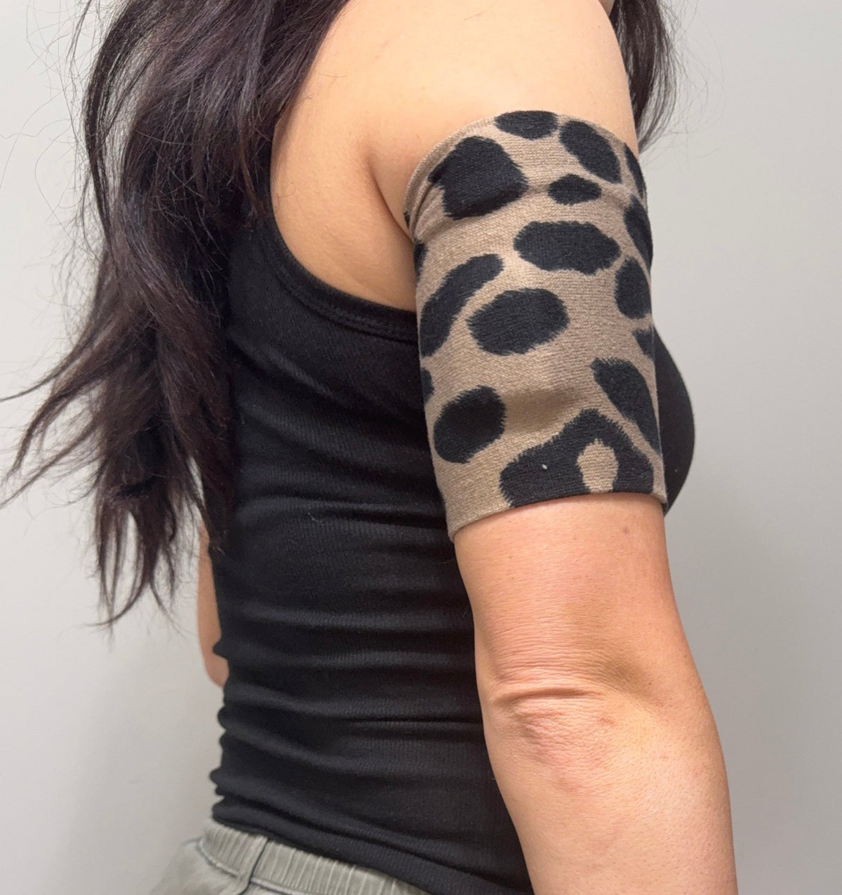 Cozy pod band in Tan & Black Cheetah worn on the upper arm over a pod