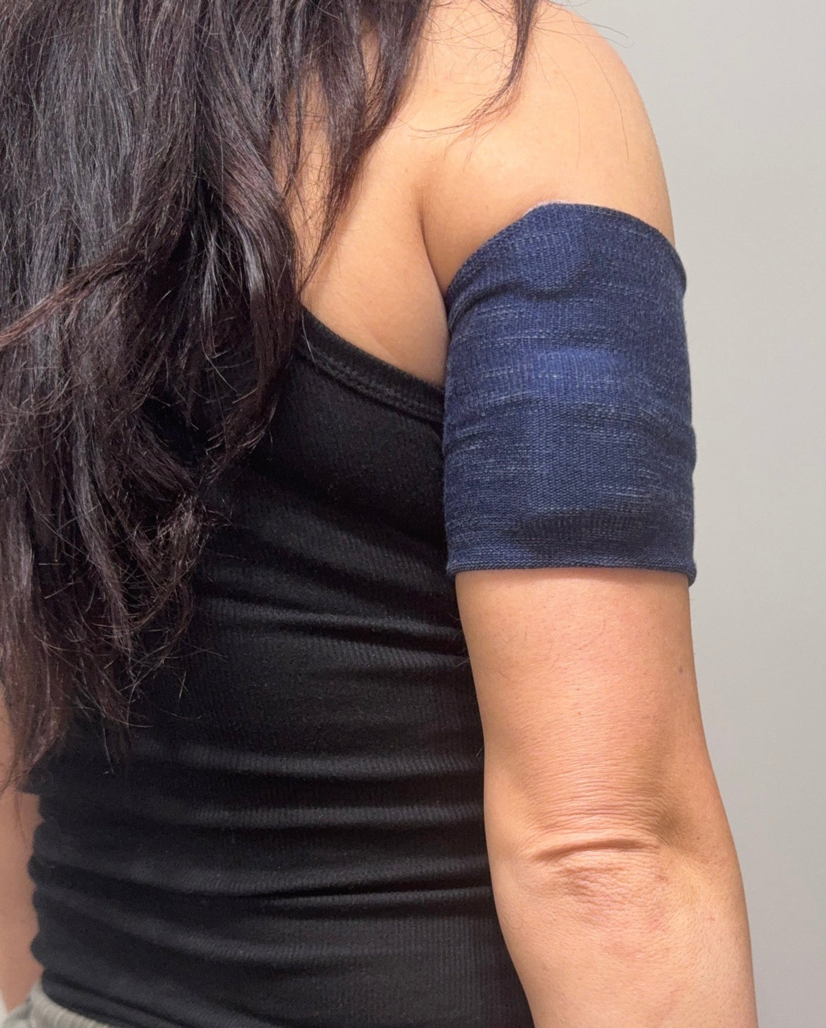 Cozy pod band in Navy Denim worn on the upper arm over a pod