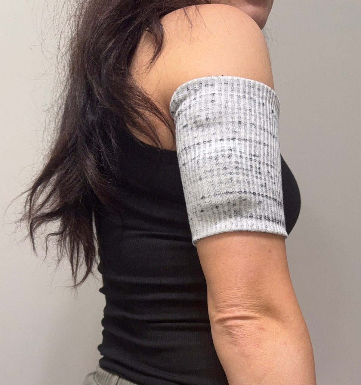 Black and white marled ribbed pod band worn on the upper arm over a pod