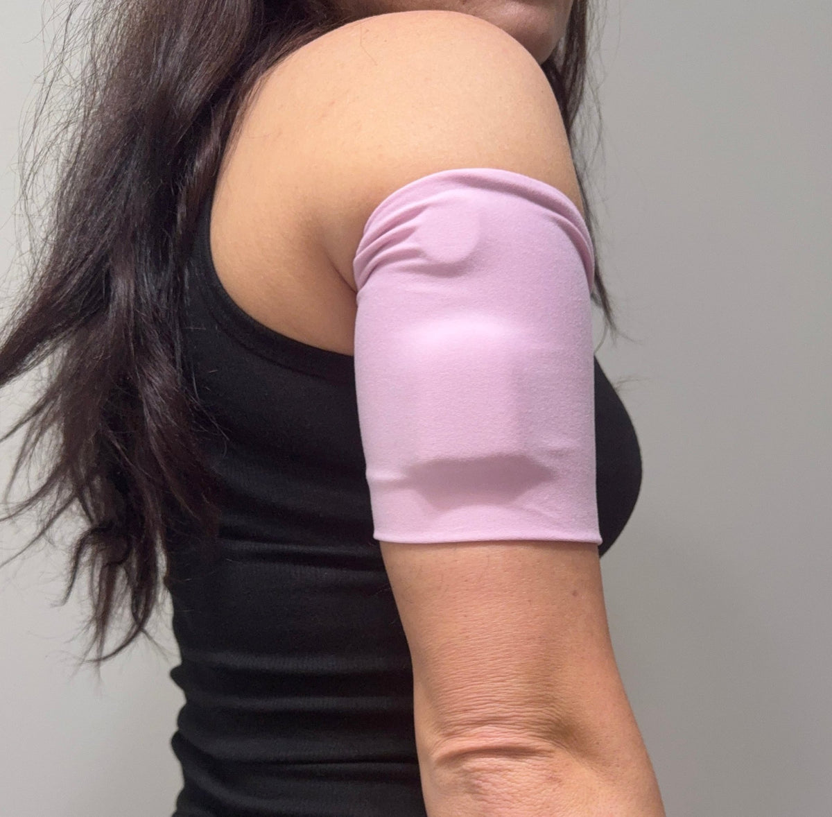 Soft cotton-feel pod band in Blush worn on the upper arm over a pod