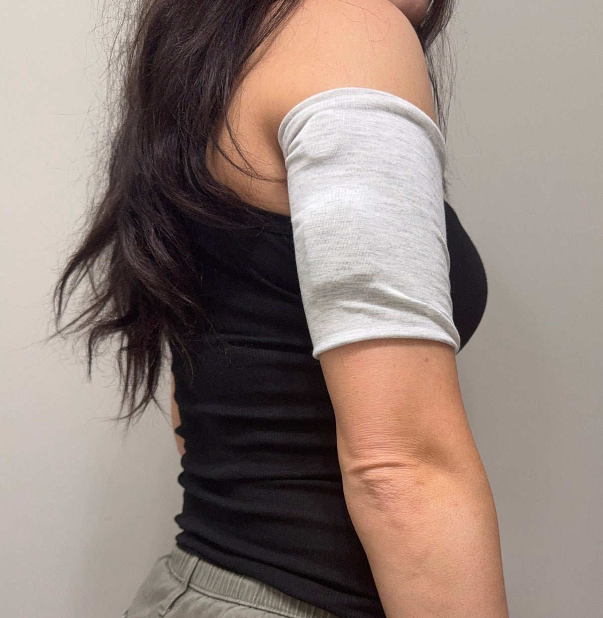 Soft cotton-feel pod band in Gray Heather worn on the upper arm over a pod