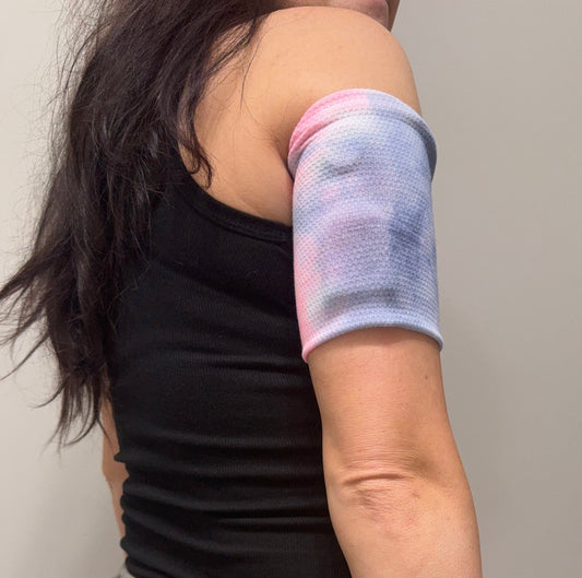 Waffle knit pod band in pink, white, blue and green tie dye worn on the upper arm over a pod