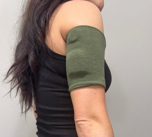 Soft cotton-feel pod band in Green Heather worn on the upper arm over a pod