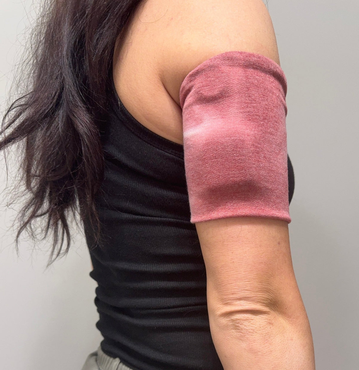 Cozy pod band in Red & Gray Tie Dye worn on the upper arm over a pod