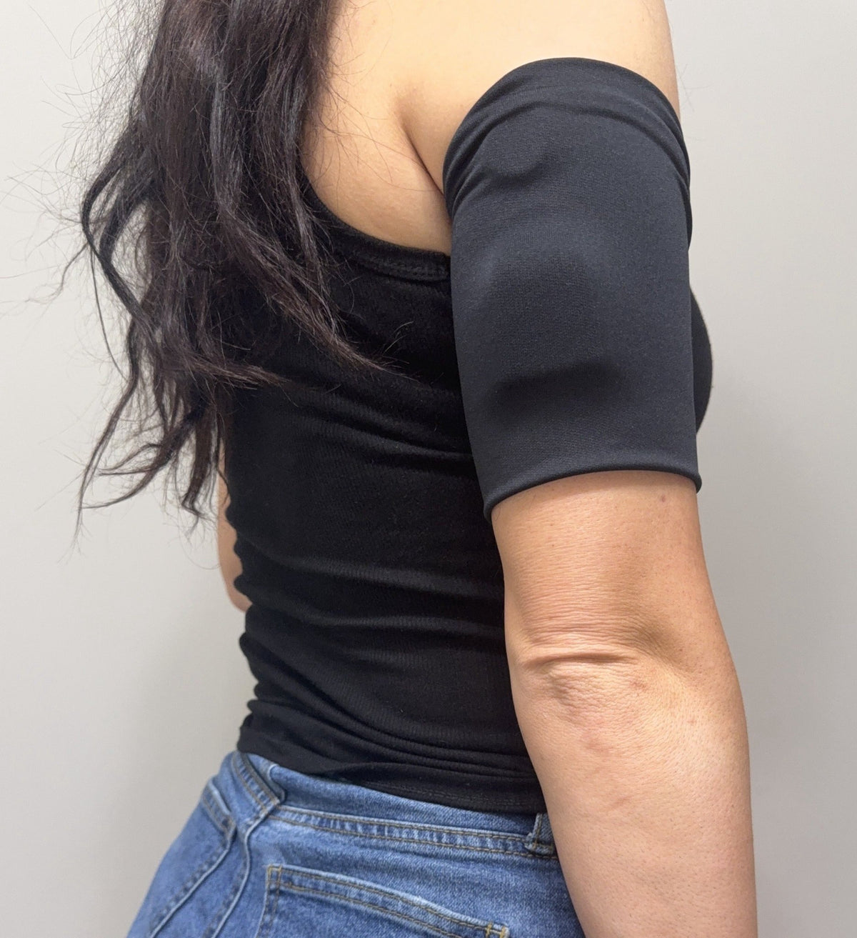 Cozy pod band in Black worn on the upper arm over a pod