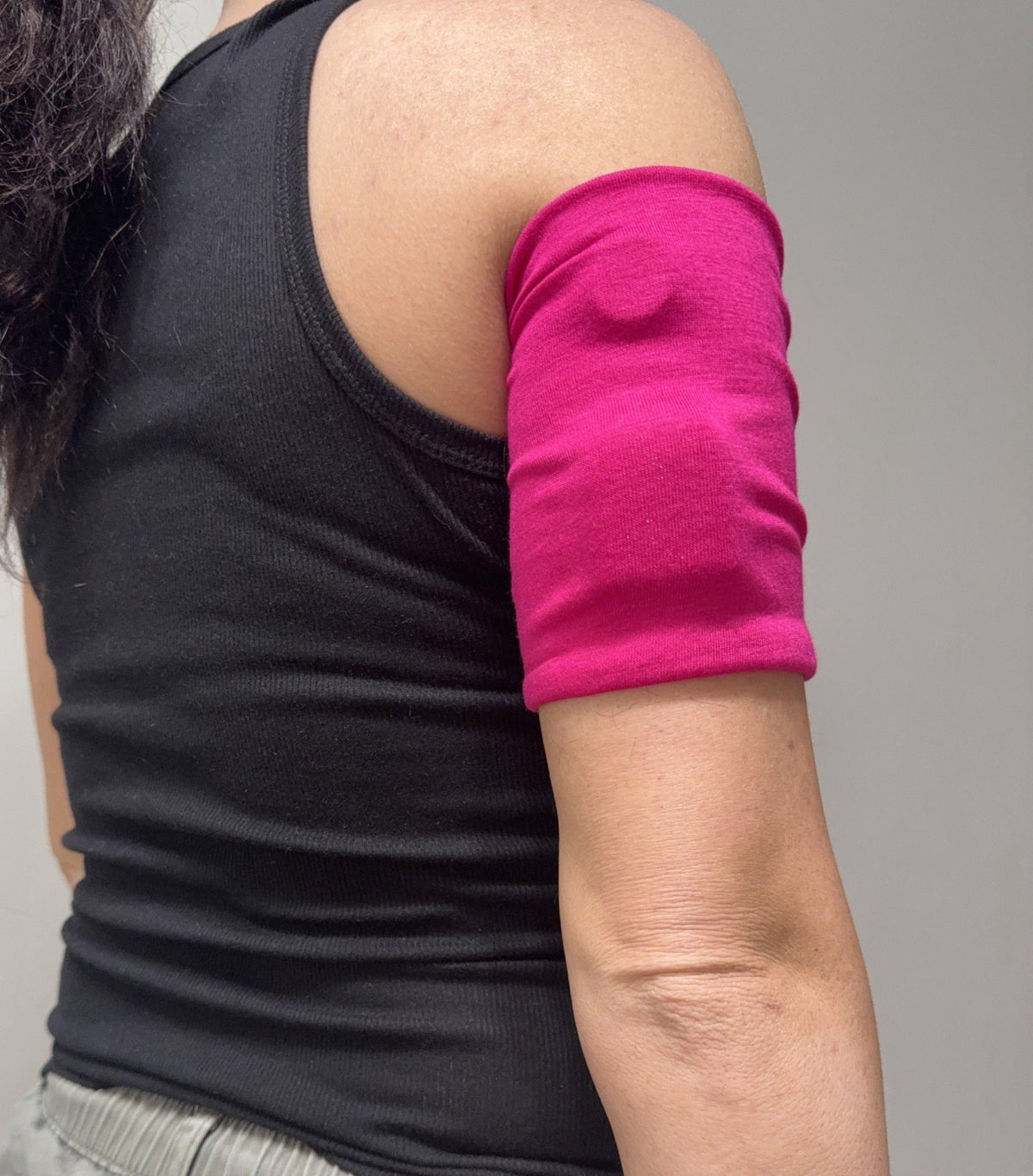 Cozy pod band in Hot Pink worn on the upper arm over a pod
