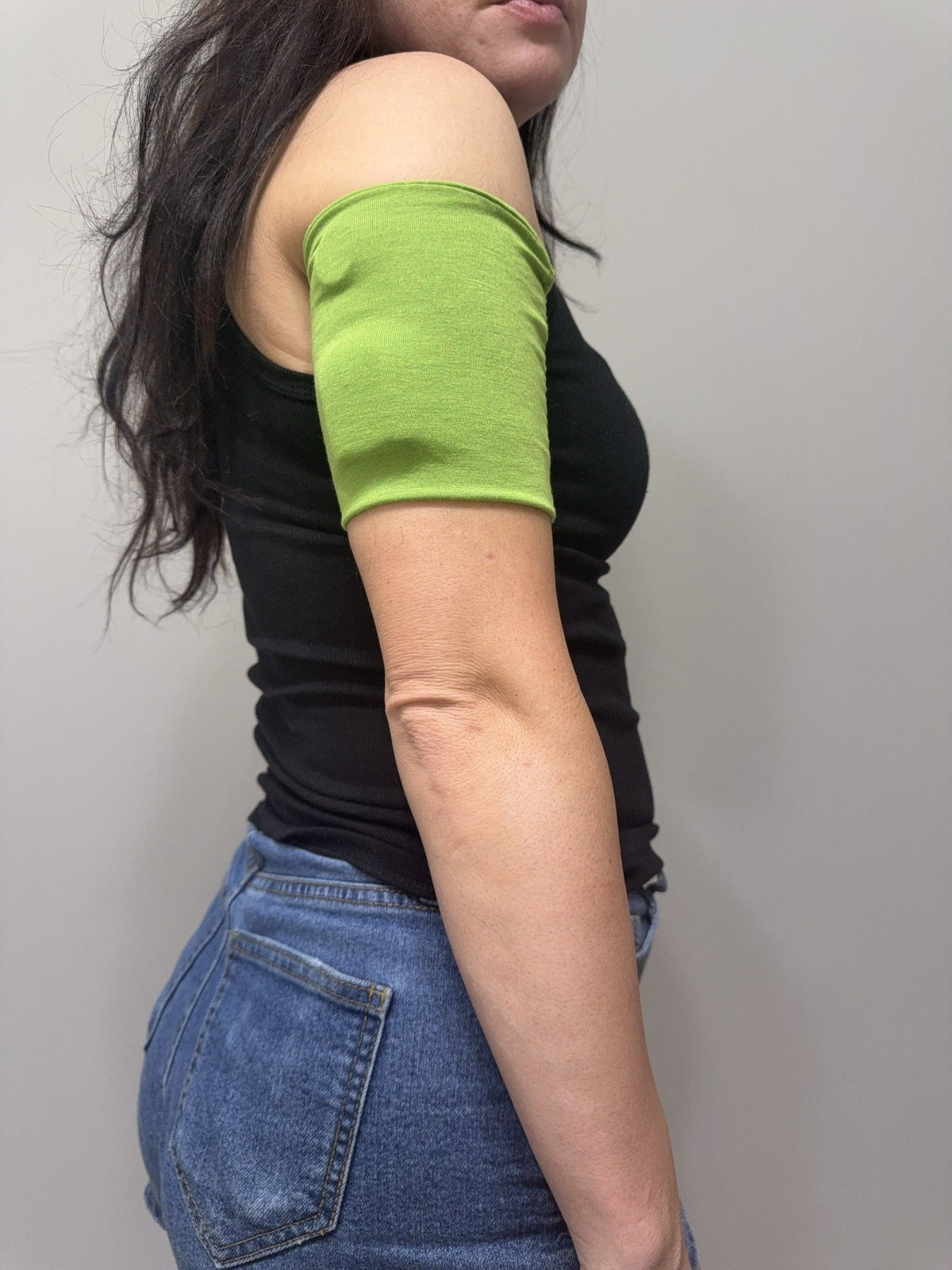 Soft cotton-feel pod band in Lime Green worn on the upper arm over a pod