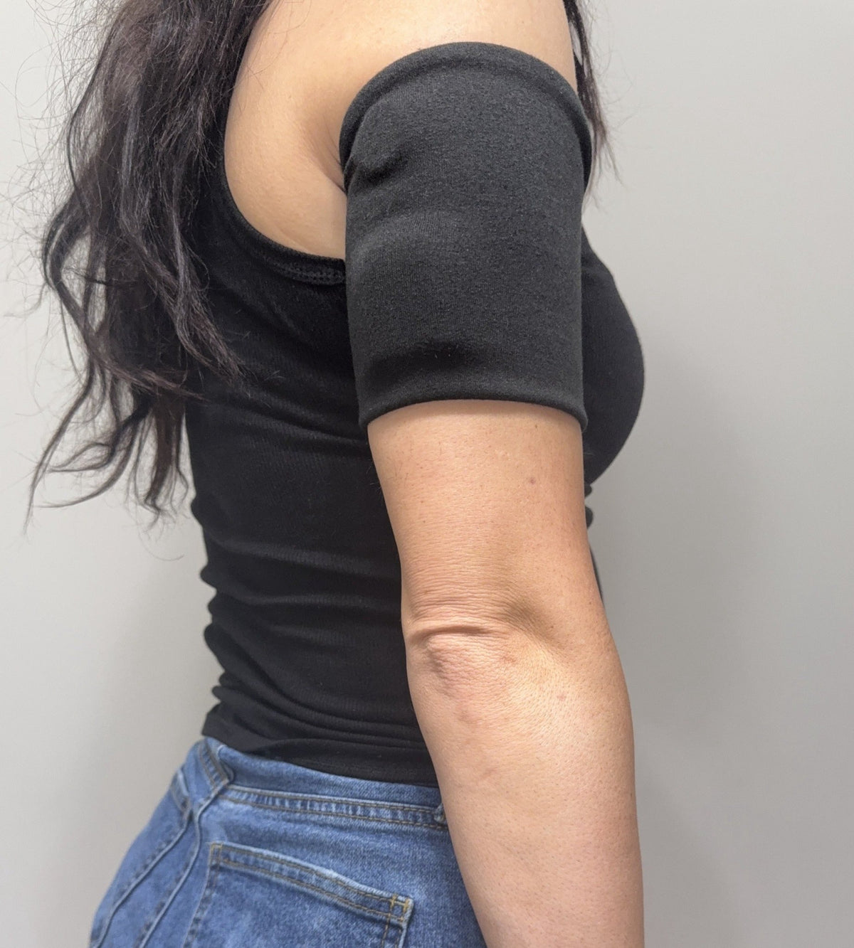 Cozy pod band in Shiny Black worn on the upper arm over a pod